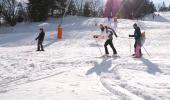Skieurs et snowboardeurs dévalant une piste enneigée