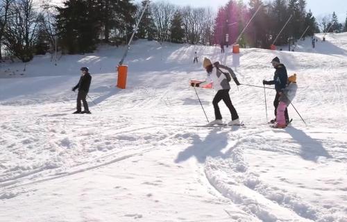 Skieurs et snowboardeurs dévalant une piste enneigée
